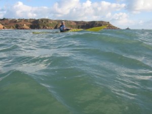 Sea kayaks in swell near Portelet Jersey