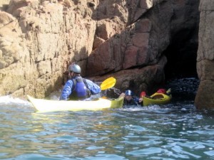 kayaker helping paddler get out of a cave